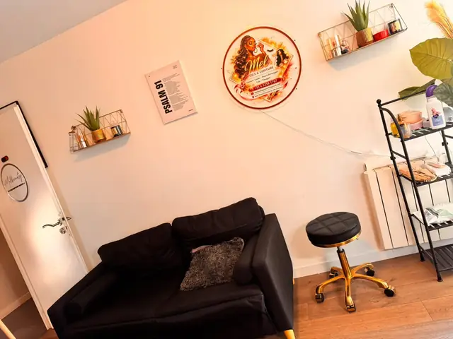 Le coin d'attente de la Mel Beauty Room avec canapé noir